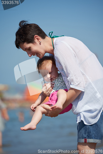 Image of mom and baby on beach  have fun