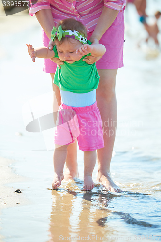 Image of mom and baby on beach  have fun