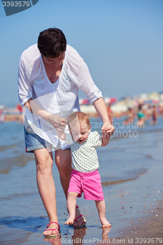 Image of mom and baby on beach  have fun