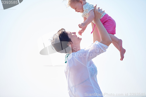 Image of mom and baby on beach  have fun