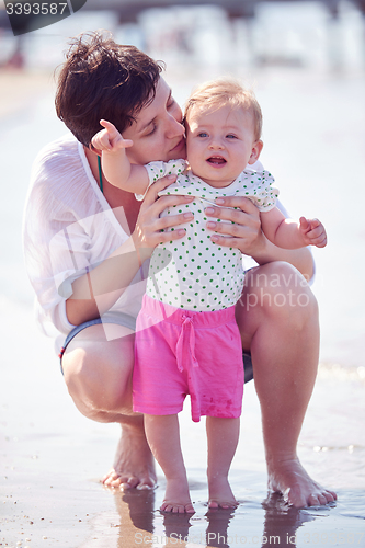 Image of mom and baby on beach  have fun