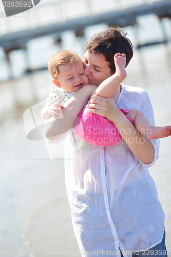 Image of mom and baby on beach  have fun