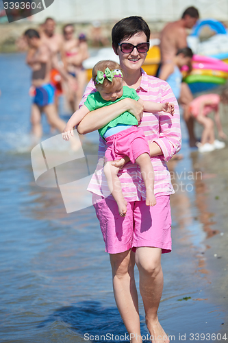 Image of mom and baby on beach  have fun