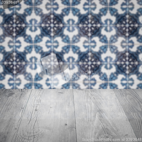 Image of Wood table top and blur vintage ceramic tile pattern wall