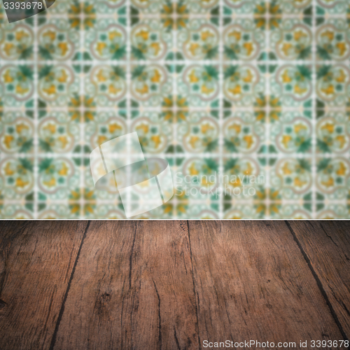 Image of Wood table top and blur vintage ceramic tile pattern wall