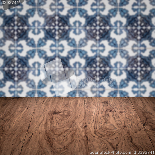 Image of Wood table top and blur vintage ceramic tile pattern wall