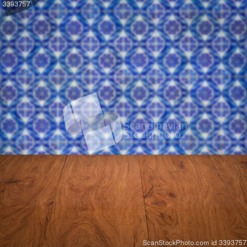 Image of Wood table top and blur vintage ceramic tile pattern wall