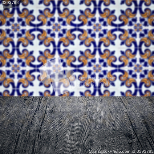 Image of Wood table top and blur vintage ceramic tile pattern wall