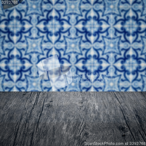 Image of Wood table top and blur vintage ceramic tile pattern wall