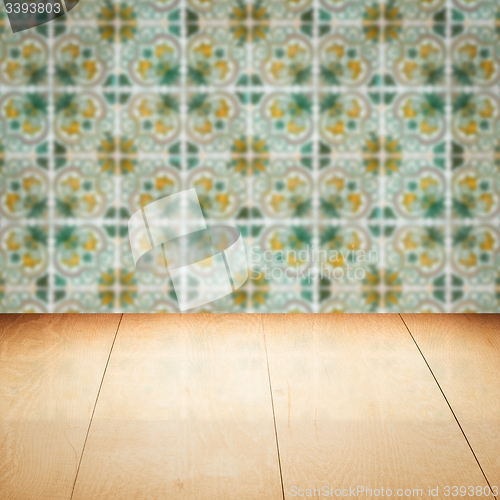 Image of Wood table top and blur vintage ceramic tile pattern wall