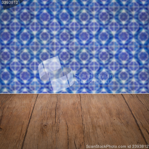 Image of Wood table top and blur vintage ceramic tile pattern wall
