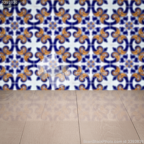 Image of Wood table top and blur vintage ceramic tile pattern wall
