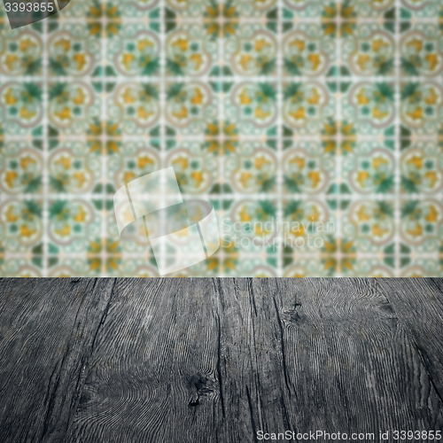 Image of Wood table top and blur vintage ceramic tile pattern wall