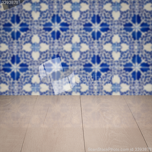 Image of Wood table top and blur vintage ceramic tile pattern wall