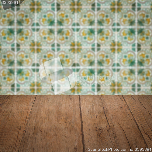 Image of Wood table top and blur vintage ceramic tile pattern wall