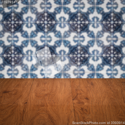 Image of Wood table top and blur vintage ceramic tile pattern wall