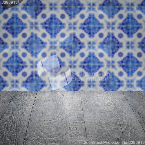 Image of Wood table top and blur vintage ceramic tile pattern wall