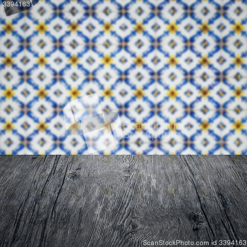 Image of Wood table top and blur vintage ceramic tile pattern wall