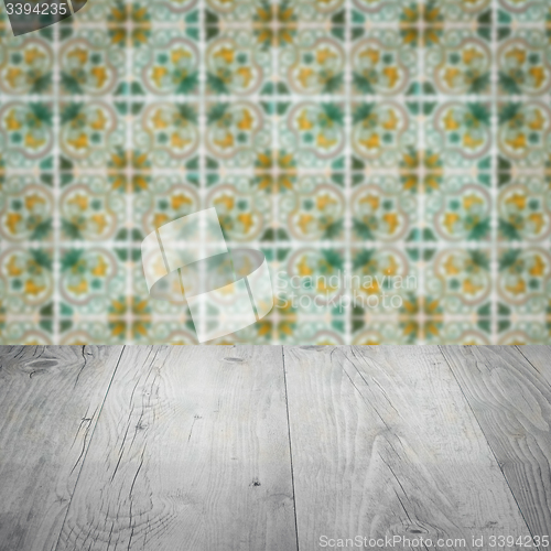Image of Wood table top and blur vintage ceramic tile pattern wall