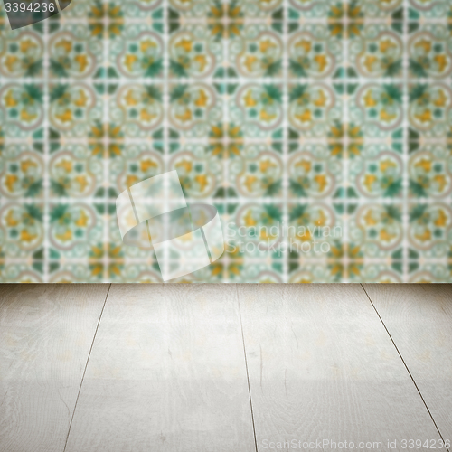 Image of Wood table top and blur vintage ceramic tile pattern wall