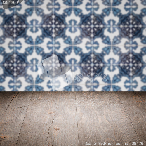 Image of Wood table top and blur vintage ceramic tile pattern wall