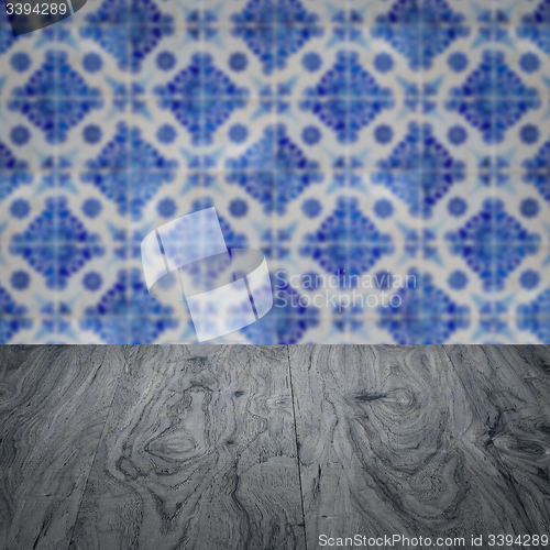 Image of Wood table top and blur vintage ceramic tile pattern wall