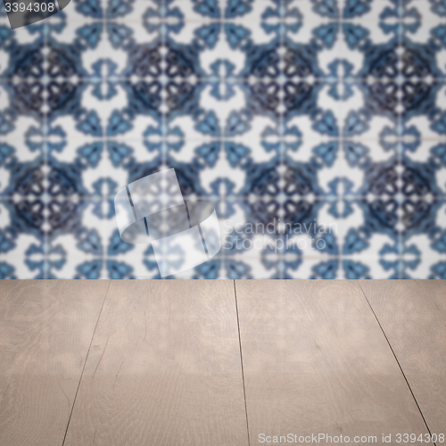 Image of Wood table top and blur vintage ceramic tile pattern wall