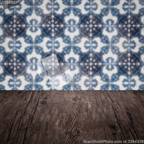 Image of Wood table top and blur vintage ceramic tile pattern wall
