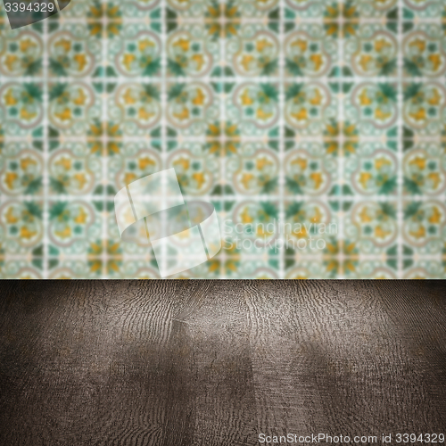 Image of Wood table top and blur vintage ceramic tile pattern wall