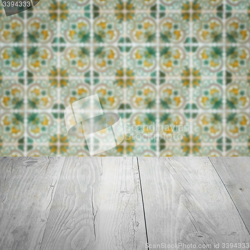 Image of Wood table top and blur vintage ceramic tile pattern wall