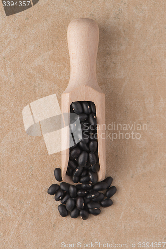 Image of Wooden scoop with black beans