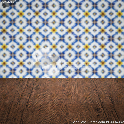 Image of Wood table top and blur vintage ceramic tile pattern wall