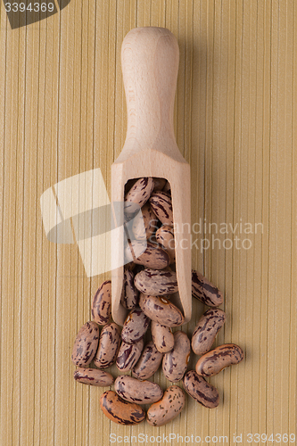 Image of Wooden scoop with pinto beans