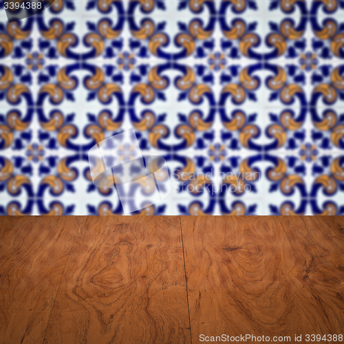 Image of Wood table top and blur vintage ceramic tile pattern wall