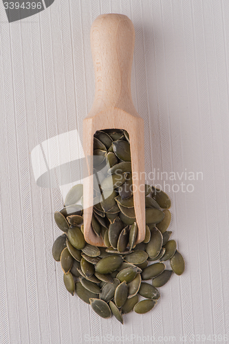 Image of Wooden scoop with pumpkin seeds