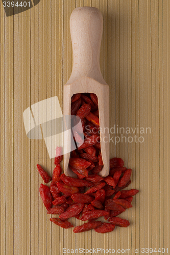 Image of Wooden scoop with dry red goji berries