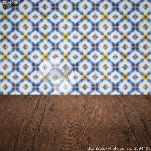 Image of Wood table top and blur vintage ceramic tile pattern wall