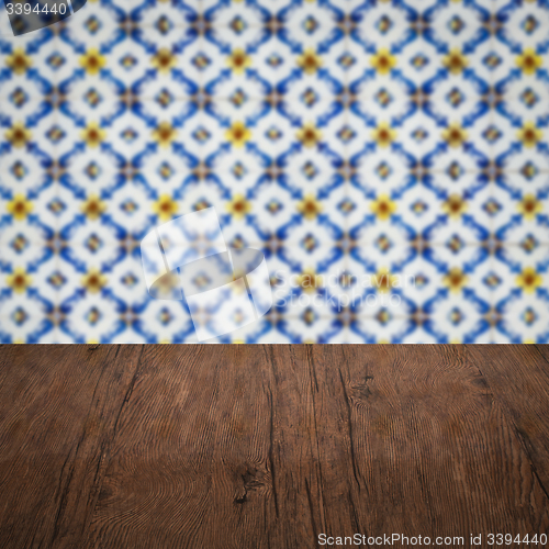 Image of Wood table top and blur vintage ceramic tile pattern wall