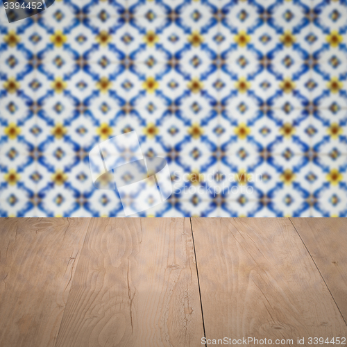 Image of Wood table top and blur vintage ceramic tile pattern wall