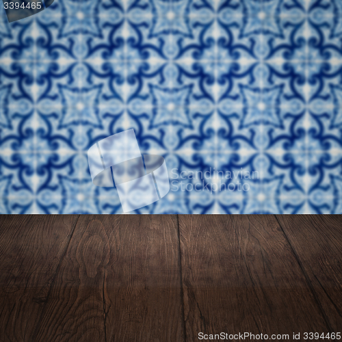 Image of Wood table top and blur vintage ceramic tile pattern wall