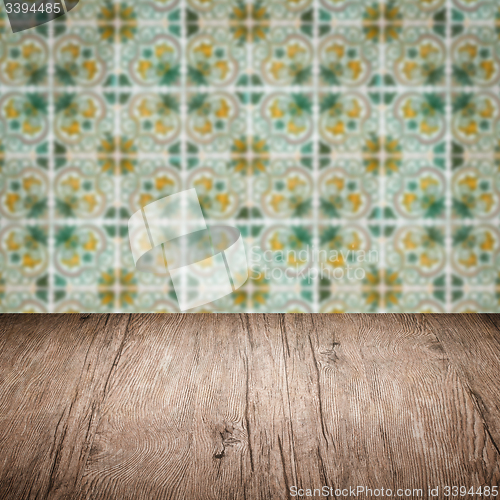 Image of Wood table top and blur vintage ceramic tile pattern wall