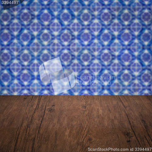 Image of Wood table top and blur vintage ceramic tile pattern wall