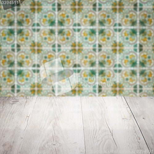 Image of Wood table top and blur vintage ceramic tile pattern wall