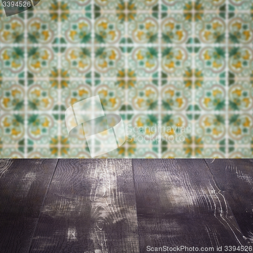 Image of Wood table top and blur vintage ceramic tile pattern wall