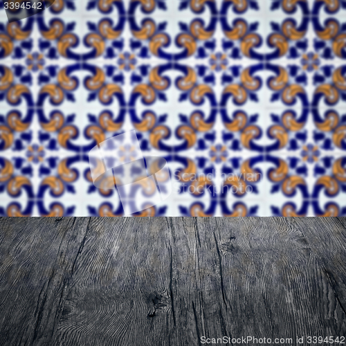 Image of Wood table top and blur vintage ceramic tile pattern wall