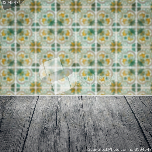 Image of Wood table top and blur vintage ceramic tile pattern wall