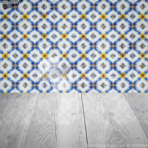 Image of Wood table top and blur vintage ceramic tile pattern wall