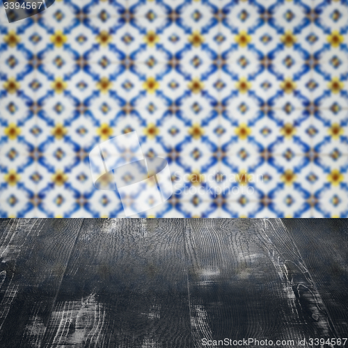 Image of Wood table top and blur vintage ceramic tile pattern wall