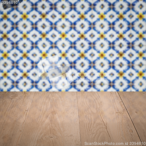 Image of Wood table top and blur vintage ceramic tile pattern wall