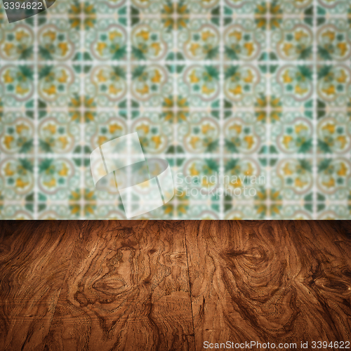 Image of Wood table top and blur vintage ceramic tile pattern wall